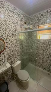 a bathroom with a toilet and a shower and a sink at Paúba House in São Sebastião