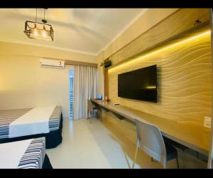 een slaapkamer met een bed en een bureau met een televisie bij Spazzio diRoma c/Acqua Park!! in Caldas Novas