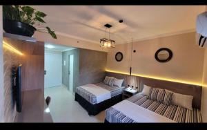 a hotel room with two beds and a tv at Spazzio diRoma c/Acqua Park!! in Caldas Novas