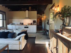 a living room with a couch and a kitchen at Chalé Mezio in Mezio +26 photos