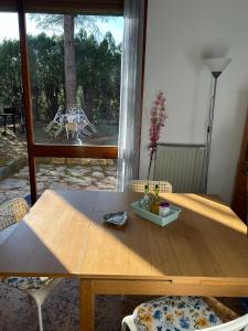 a wooden table with chairs in a room with a window at Casa con giardino: Varazze in Varazze