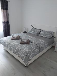 een bed met een grijs en wit dekbed en kussens bij Apartment Marina 2 in Kotor