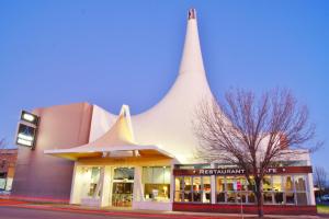 ein Gebäude mit spitzem Dach auf einer Straße in der Unterkunft Mantra Pavilion Hotel Wagga in Wagga Wagga