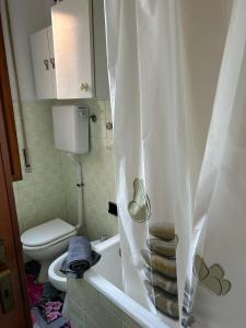 a bathroom with a toilet and a shower curtain at Casa con giardino: Varazze in Varazze