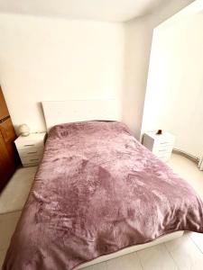 1 dormitorio con 1 cama grande con manta morada en 3 bedrooms flat near of the beach en Barcelona