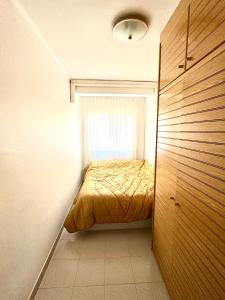 a small bedroom with a bed and a window at 3 bedrooms flat near of the beach in Barcelona