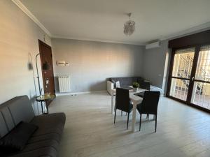 a living room with a couch and a table and chairs at Appartamento del Parco in Lunghezza +16 photos