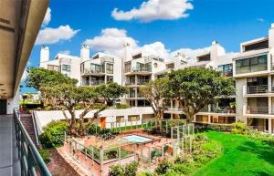 a large white apartment building with a swimming pool at Santa Monica Beach Amazing 2 Bedroom Condo in Los Angeles