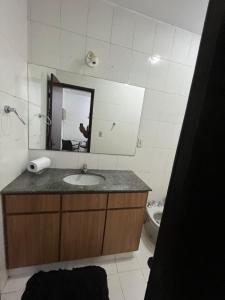 a bathroom with a sink and a mirror and a toilet at Hostel e Restaurante Dona Lu in Itaperuna