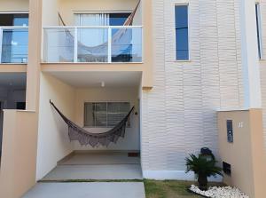een hangmat hangt aan de zijkant van een huis bij JPN87 - Duplex em condomínio fechado próx. à praia in Natal