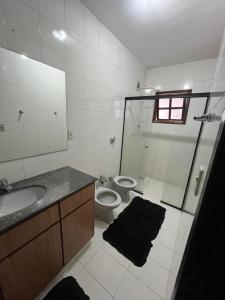 a bathroom with a shower and a toilet and a sink at Hostel e Restaurante Dona Lu in Itaperuna