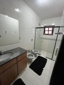 a bathroom with a shower and a toilet and a sink at Pousada e Restaurante Dona Lu in Itaperuna