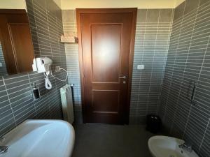 un bagno con lavandino, servizi igienici e porta di Appartamento del Parco a Lunghezza