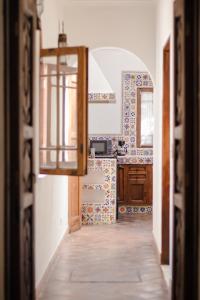 a kitchen with a hallway leading to a kitchen with tiles at Casa Liza in San Miguel de Allende