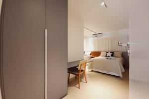 een slaapkamer met een bed en een bureau naast een bed bij JPN87 - Duplex em condomínio fechado próx. à praia in Natal