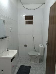 a white bathroom with a toilet and a sink at HOTEL ATLANTA in Paulistana