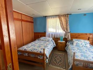 een slaapkamer met 2 bedden en een raam bij Casa acogedora Nalhuitad in Rauco