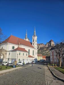 un grand bâtiment blanc avec une église avec une cloche dans l'établissement Szent István koronája, à Esztergom