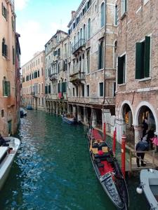 two gondolas in a canal between two buildings at Venice Tourist House in Venice