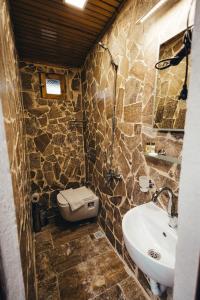 a stone bathroom with a sink and a toilet at Turan Cappadocia Cave in Goreme