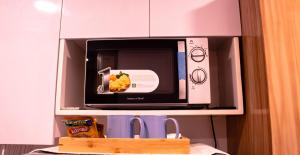 cocina con microondas y estante en 38 Park Avenue Condominium, en Cebú
