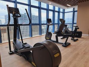 un gimnasio con máquinas cardiovasculares en una habitación con ventanas en 38 Park Avenue Condominium, en Cebú