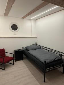 - une chambre avec un lit et une chaise rouge dans l'établissement Alter Speicher, à Schönberg