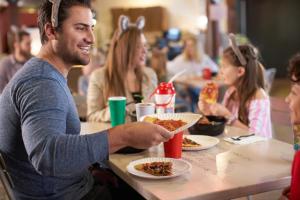 un hombre sentado en una mesa comiendo comida en Great Wolf Lodge Concord, en Concord