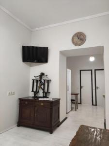 sala de estar con tocador y reloj en la pared en BANDERA Hostel, en Leópolis