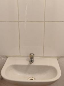 lavabo blanco con grifo en el baño en Loft Florentino 302, en Lima