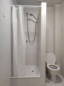 y baño con ducha, aseo y cortina de ducha. en BANDERA Hostel, en Leópolis