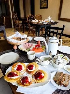 a table topped with plates of pastries and tea pots at Dobre wCzasy in Stronie Śląskie
