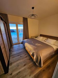 ein Schlafzimmer mit einem Bett und einem großen Fenster in der Unterkunft Veselé Apartmány Lipno in Lipno nad Vltavou