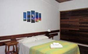 a bedroom with a bed with two towels on it at HOTEL LA TOSCANA in San Ignacio