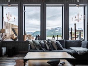 uma sala de estar com um sofá e vistas para as montanhas em Åre Valley Lodges - Kopparvillan em Åre