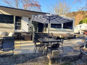 una mesa con una sombrilla delante de una caravana en Jolene, en Gatlinburg