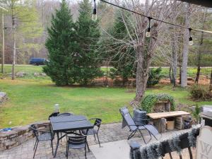 um pátio com uma mesa, cadeiras e comodidades para churrascos em Jolene em Gatlinburg