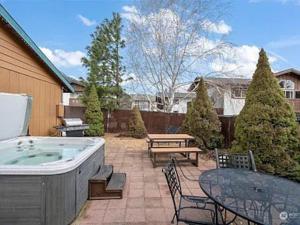 a patio with a hot tub and a table and chairs at Cozy Bavarian Getaway in Leavenworth