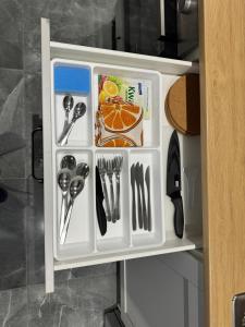 a small refrigerator with utensils in it at Brooklyn Apartaments Parking on Street in Katowice +13 photos