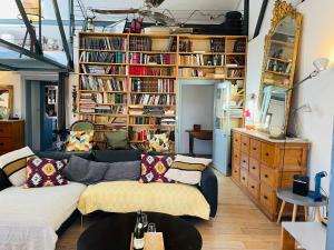 - un salon avec un canapé et des étagères dans l'établissement Loft 120m2 avec Terrasse Centre Historique, à Montpellier