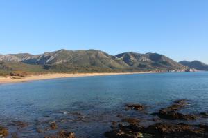 弗盧米尼馬焦雷的住宿－Agriturismo Perdaba，享有海滩美景,背景为群山