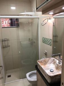 a bathroom with a shower and a sink and a toilet at Casa com AR COND. em todos os comodos mobiliada in Cascavel