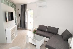 ein Wohnzimmer mit einem Sofa und einem Tisch in der Unterkunft Apartments Maja in Rogoznica