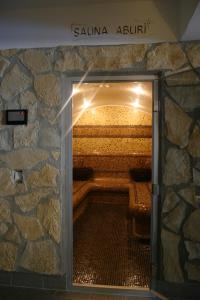 a door to a sauna behind a stone wall at Cheile Gradistei Fundata Resort in Fundata