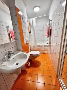 uma casa de banho laranja e branca com um lavatório e um WC. em Piata Ovidiu 14 em Constança