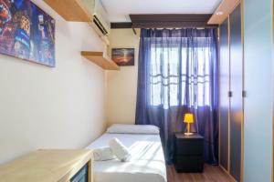 a small room with a bed and a window at Apartment Aconte Malaga in Málaga