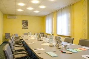 una sala de conferencias con una mesa larga y sillas en Hotel Wieting en Oldenburg