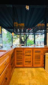 a large kitchen with wooden cabinets and a large window at Coffee House Minca in Minca