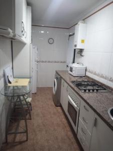 una pequeña cocina con fogones y fregadero en Apartamento Tahalia 3 habitaciones, en Huelva