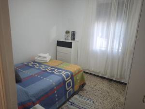Habitación pequeña con cama y ventana en Apartamento Tahalia 3 habitaciones, en Huelva
